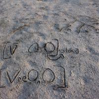 Linguistic symbols written in the sand.