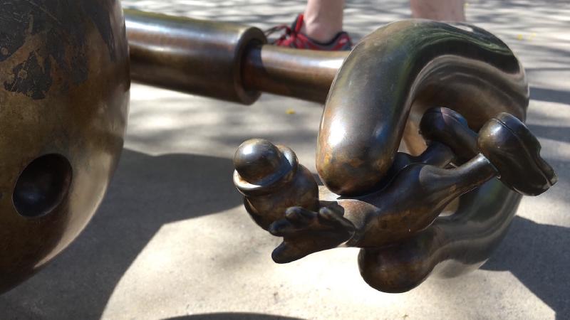 Photograph of a bronze figurine caught in the grip of a creature